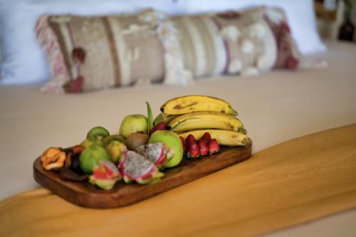 a wooden table topped with fruit and vegetables at Alaya Tulum in Tulum