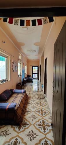 a living room with a couch and a tile floor at Tebaar Backpackers in Rishīkesh