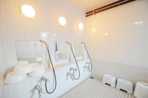 a bathroom with two sinks and two mirrors at Hotel Saharin in Wakkanai