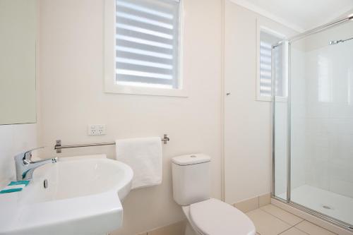 a white toilet sitting next to a bath tub at La Costa Beachside Motel in Gold Coast