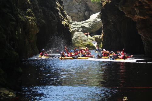 a group of people are rafting down a river at MALI Boutique Lodge & Tube 'n Axe Budget Accommodation in Stormsrivier