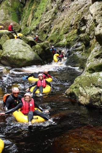 a group of people rafting down a river in kayaks at MALI Boutique Lodge & Tube 'n Axe Budget Accommodation in Stormsrivier