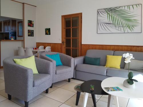 a living room with two chairs and a couch at Le Gecko Vert in Manapany-les Bains