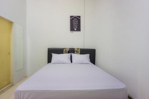 Giường trong phòng chung tại OYO Life 2366 Gatsu Kost