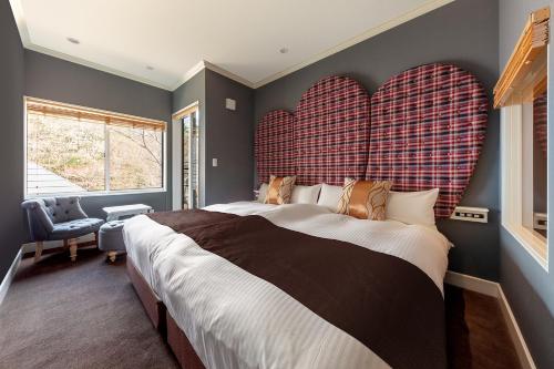 a bedroom with a large bed with two large hearts on the wall at Karuizawa Hotel Longing House in Karuizawa