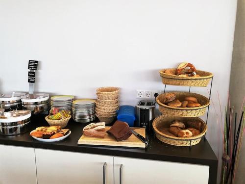 a kitchen counter with baskets of food and plates at iQ-Hotel Ulm in Ulm