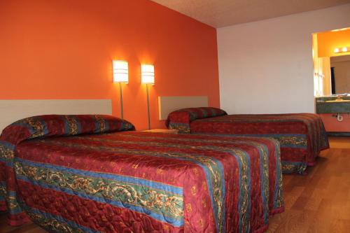 a hotel room with two beds and orange walls at Sherman Inn in Sherman