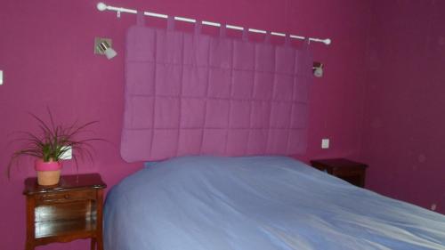 a purple bedroom with a bed and two night stands at Chez Catherine et Roger in Brouvelieures