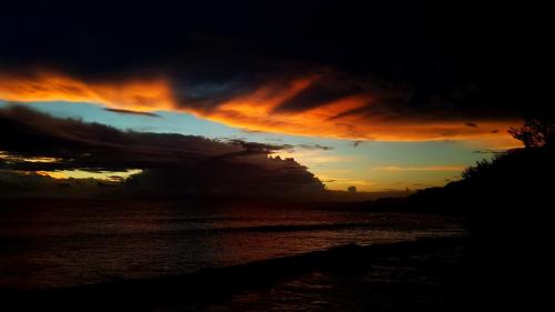 a sunset over a body of water at Le Gecko Vert in Manapany-les Bains
