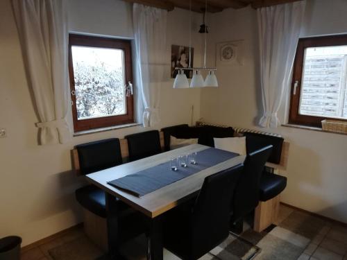 阿布特瑙的住宿－Gaestehaus-Russegger，一间带桌子和黑色椅子的用餐室
