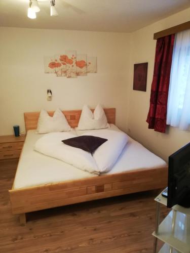 a bedroom with a large bed with white sheets at Gaestehaus-Russegger in Abtenau
