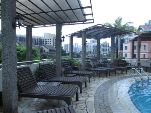 a hotel patio with benches and a swimming pool at Robertson Quay Hotel in Singapore