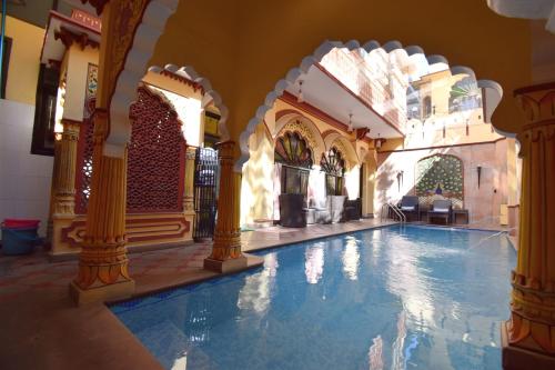 a large swimming pool in a building with a swimming pool at Umaid Mahal - A Heritage Style Boutique Hotel in Jaipur