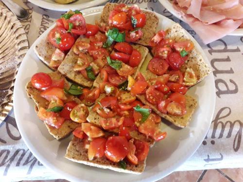 a plate of toast with tomatoes and cheese on it at Agriturismo Torre Cristina in Aprilia