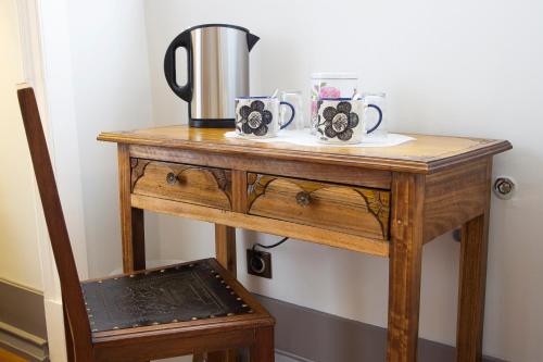 a wooden table with two mugs and a kettle on it at Chalet Saudade in Sintra