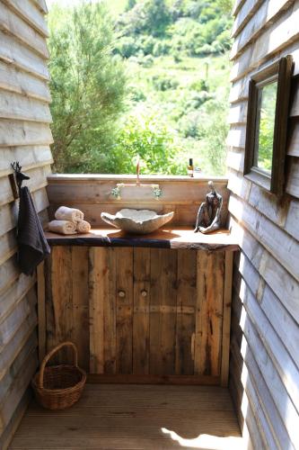 a bathroom with a sink on a wooden wall at Kereru site in Waihi