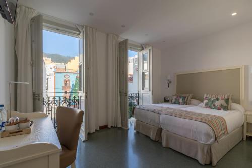 a hotel room with a bed and a balcony at Hotel Emblemático Holiday Time in Santa Cruz de la Palma