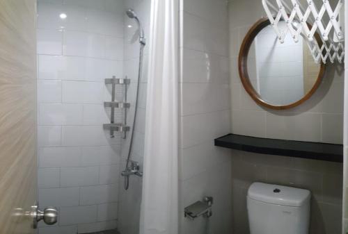 y baño con ducha, aseo y espejo. en Ruby Apartment #1, en Yogyakarta