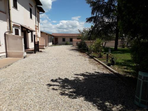 a gravel road next to a house with a tree at Agriturismo Torre Cristina in Aprilia