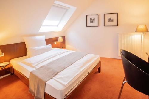 Schlafzimmer mit einem großen Bett und einem Dachfenster in der Unterkunft Hotel Reckord in Herzebrock