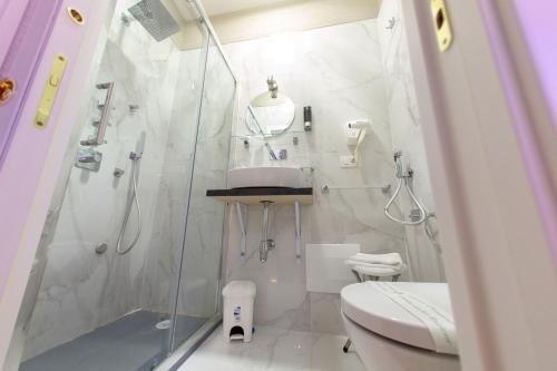 a white bathroom with a shower and a toilet at Leone Camere D'autore in Naples