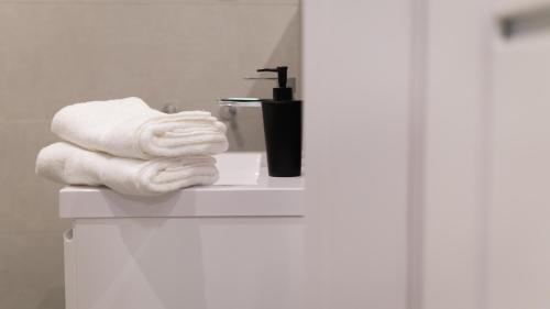 a pile of towels sitting on a bathroom sink at Apartamenty K2 Podmurna 36 in Toruń