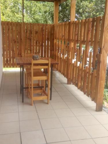 a table and bench on a patio with a fence at Oppihoek in Harrismith