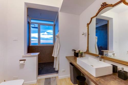 a bathroom with a sink and a mirror at Camera Deluxe in favoloso attico vista mare in Rimini