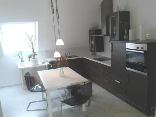 uma cozinha com armários pretos e uma mesa branca em 70qm Wohnung, 76771 Hördt, Naturschutzgebiet, Rheinland-Pfalz em Hördt
