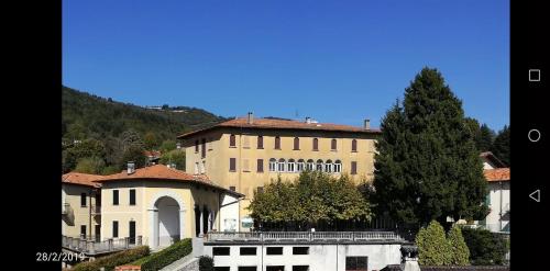 a large building with a tree in front of it at Residenza Santa Valeria in Caglio