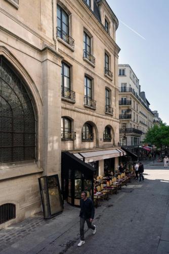 a man standing on a street in front of a building at Hôtel Le Presbytère in Paris
