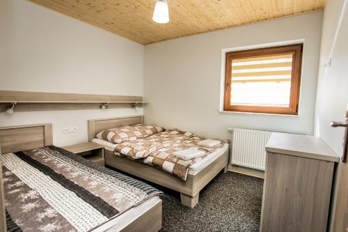 two beds in a room with a window at Ma-Mela in Polańczyk
