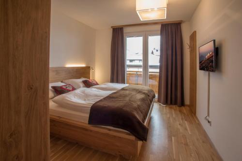sypialnia z łóżkiem i oknem w obiekcie Grossglockner Alpin Lodge w mieście Matrei in Osttirol