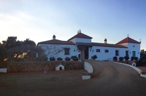 een groot wit huis met een weg ervoor bij El Encinar, Country House in Alanís, Andalusia in El Encinar