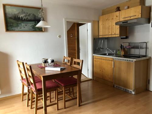 a kitchen with a wooden table and chairs in a room at Haus Helli in Berwang