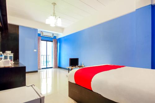 sypialnia z niebieskimi ścianami i łóżkiem z czerwonym kocem w obiekcie Super OYO 427 Chill Apartment w mieście Bangkok