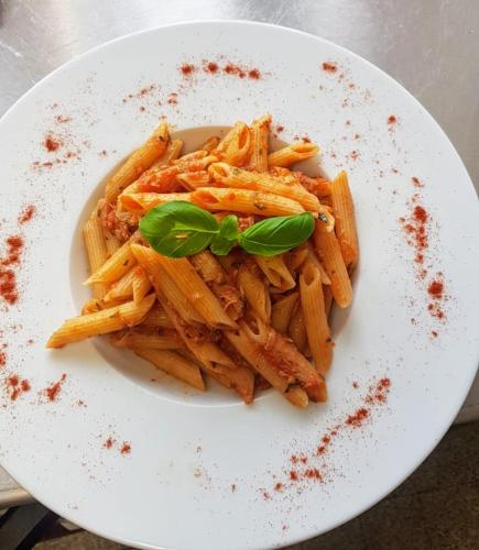 a plate of pasta with a green garnishment at L'ANGOLO DEI SAPORI in Rueun