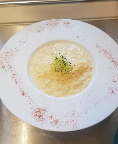 a bowl of soup on a plate on a table at L'ANGOLO DEI SAPORI in Rueun