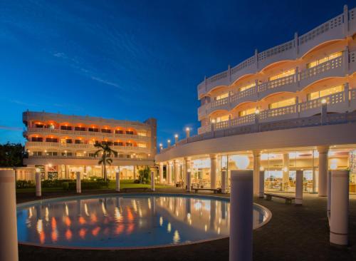 un gran edificio con una piscina frente a él en Marine Lodge Marea, en Isla Miyako