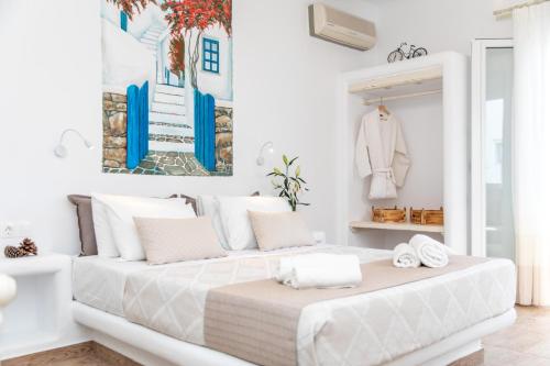 a white bedroom with a large bed with towels on it at Arhontiko in Naxos Chora