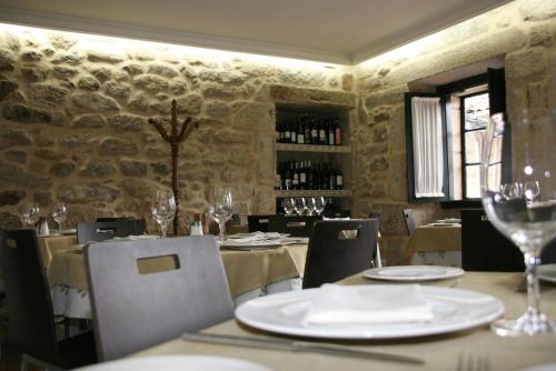 un comedor con mesas y sillas y copas de vino en Hotel Restaurante Rúas, en Pontevedra