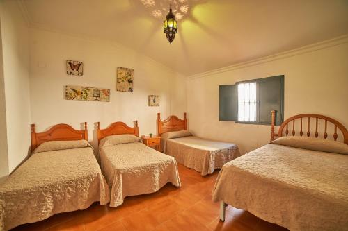 een slaapkamer met 3 bedden en een raam bij VILLA IRENE in Fuenteheridos