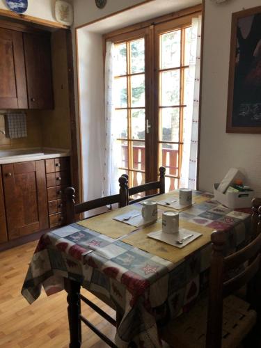 eine Küche mit einem Tisch und einem Tischtuch darauf in der Unterkunft APPARTAMENTO MONTAGNA SAUZE D OULX in Sauze dʼOulx