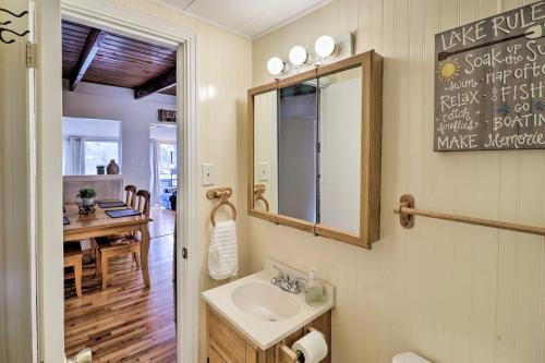 Un baño con lavabo, espejo y mesa. en Riverfront Deck and Fire Pit Hot Springs Retreat!, en Hot Springs