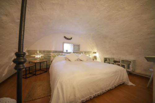 a bedroom with a white bed and a window at Trulli&Dimore - Dimora di Genna in Castellana Grotte