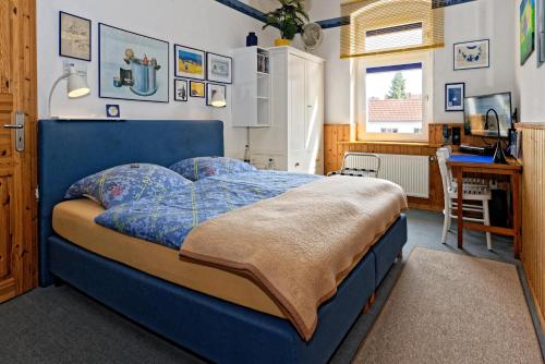 a bedroom with a blue bed and a desk at Moltkestrasse 89 in Hildesheim