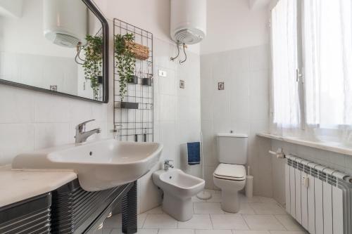 een witte badkamer met een wastafel en een toilet bij Casa Mi in Lerici