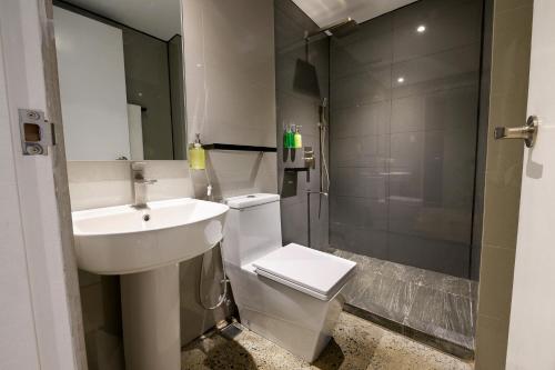 een badkamer met een wastafel, een toilet en een douche bij G1 Lodge in Baguio