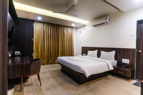 a hotel room with a bed and a chair at Hotel Manasi Royal in Satara