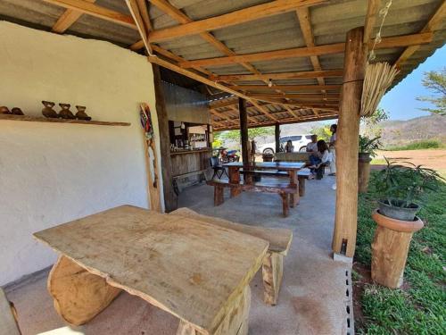 a patio with a table and a bench and a roof at Monsonkeang Camping view ม่อนสันเกี๋ยง in Mae Chaem